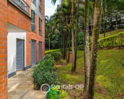 a walkway next to a building with palm trees at Spacious apartment near Lleras and Provenza rentalsOP AN08 in Medellín
