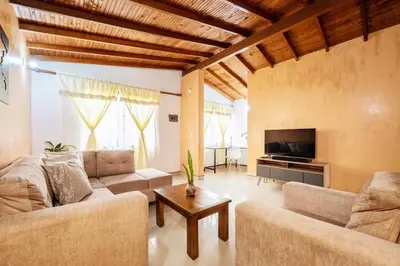 a living room with a couch and a tv at Spacious House with Garden & View over Medellin in Medellín