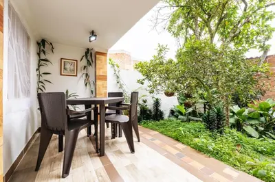 a dining room with a table and chairs on a patio at Spacious House with Garden & View over Medellin in Medellín