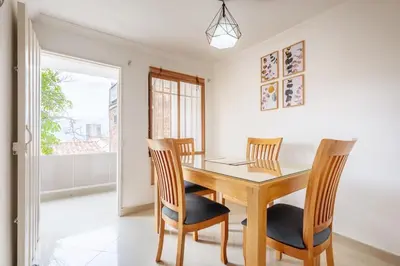 a dining room with a wooden table and chairs at Spacious House with Garden & View over Medellin in Medellín
