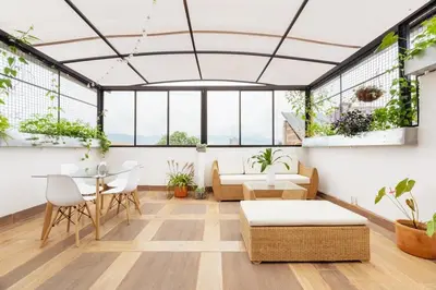 a room with a table and chairs and plants at Spacious House with Garden & View over Medellin in Medellín