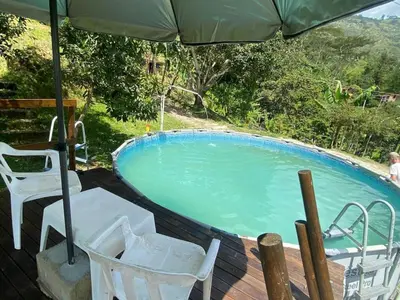 a swimming pool with two chairs and an umbrella at Finca Panoramica in Barbosa