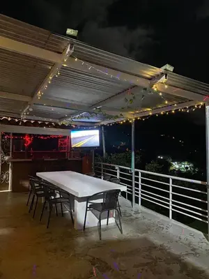 a table and chairs on a patio at night at Finca Panoramica in Barbosa