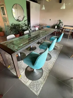 a long glass table with blue chairs in a room at Candilejas in Fredonia