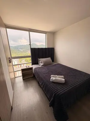 a bedroom with a bed with a large window at Apartamento Urban Manizales Acogedor in Manizales