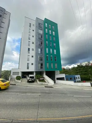 a green building with a car parked in front of it at Apartamento Urban Manizales Acogedor in Manizales