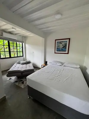 a bedroom with a large white bed and a window at Casa Bosque Vivo in Norcasia