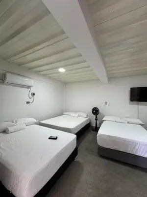two beds in a room with white walls and ceilings at Casa Bosque Vivo in Norcasia