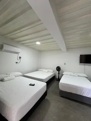 a room with two beds and a flat screen tv at Casa Bosque Vivo in Norcasia