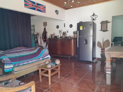 a living room with a refrigerator and a table at Casa Sol y Río in Honda
