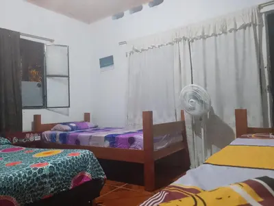 a bedroom with two beds and a fan at Casa Sol y Río in Honda