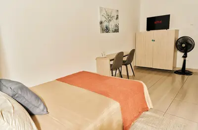 a bedroom with a bed and a desk with a fan at Apartamento A108 en el Poblado in Medellín