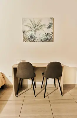 two chairs sitting next to a desk with a painting at Apartamento A108 en el Poblado in Medellín