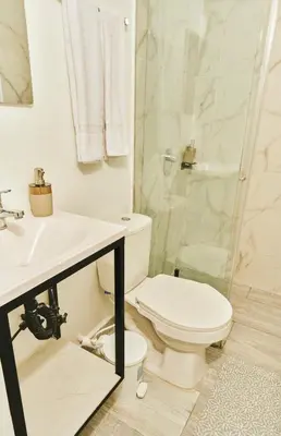a white bathroom with a toilet and a shower at Apartamento A108 en el Poblado in Medellín