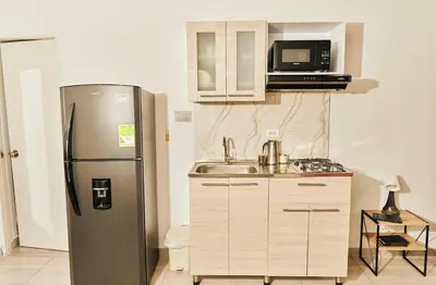 a kitchen with a refrigerator and a sink and a microwave at Apartamento A108 en el Poblado in Medellín
