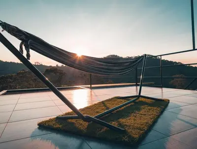 a hammock on top of a balcony with the sunset at Glamping La Maestranza con desayuno incluido in Estación El Salto