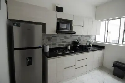 a kitchen with a refrigerator and a microwave at Medellin La 70 - Laureles in Medellín