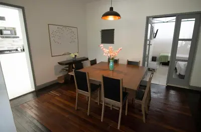 a dining room table with chairs and a vase of flowers at Medellin La 70 - Laureles in Medellín