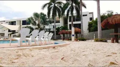 a group of white chairs sitting next to a pool at Apartasol por días en condominio ciudadela Santa Fe de Antioquia in Santa Fe de Antioquia