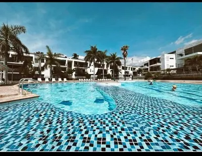 a large swimming pool with blue and white tiles at Apartasol por días en condominio ciudadela Santa Fe de Antioquia in Santa Fe de Antioquia