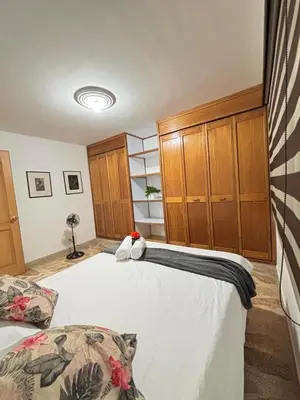 a bedroom with a large bed and wooden cabinets at Unbeatable location in Medellín in Medellín