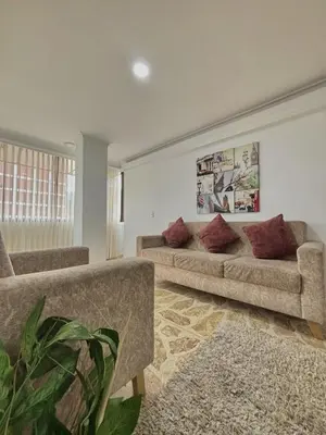 a living room with two couches and a plant at Confort y Estilo en el Centro de Medellín Perfecto para tu Estancia in Medellín