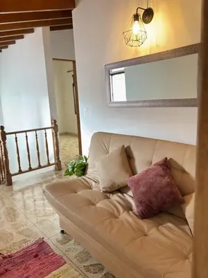 a brown couch in a living room with a mirror at Confort y Estilo en el Centro de Medellín Perfecto para tu Estancia in Medellín