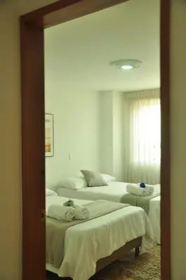 two beds in a room with a mirror at live Medellín desde un Apartamento Céntrico y Cómodo in Medellín
