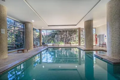 a large swimming pool in a house with a large window at PORTANOVA SUITES - Apartamento de lujo, muy cómodo, a tan sólo 5 minutos del aeropuerto JMC in Rionegro