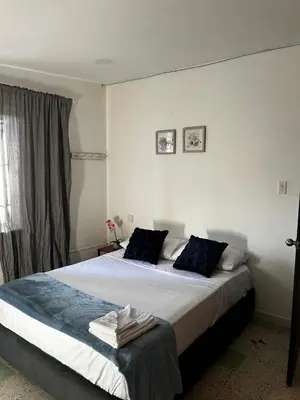 a bedroom with a large bed with blue pillows at Jireh alojamientos in Medellín