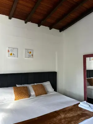 a bedroom with a bed with white sheets and a mirror at Jireh alojamientos in Medellín