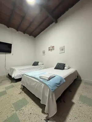 a room with two beds and a flat screen tv at Jireh alojamientos in Medellín