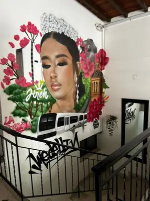 a mural of a woman with a train on a wall at Jireh alojamientos in Medellín