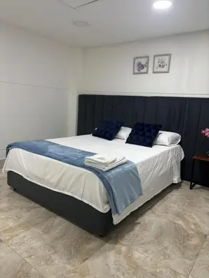 a large bed with blue pillows in a bedroom at Jireh alojamientos in Medellín