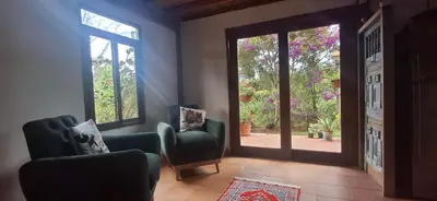 a living room with two chairs and a sliding glass door at Moss in San Isidro