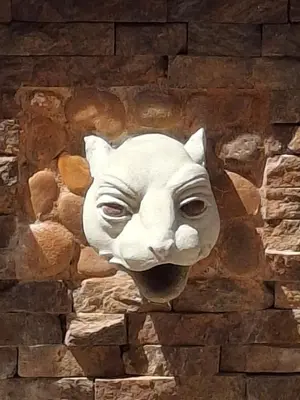 a mask of a cat on a brick wall at Moss in San Isidro