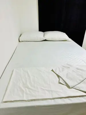 a white bed with two pillows on top of it at Apartamentos laureles estadio 101 ED MILA in Medellín