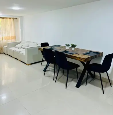 a dining room with a table and chairs and a couch at Apartamentos laureles estadio 101 ED MILA in Medellín