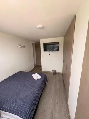 a bedroom with a bed and a flat screen tv at Apartamento en Manizales in Manizales
