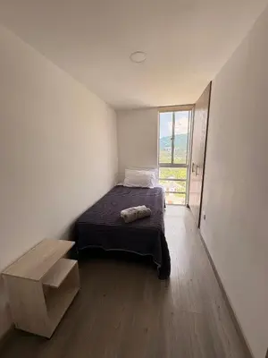 a bedroom with a bed and a large window at Apartamento en Manizales in Manizales
