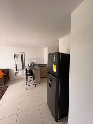 a kitchen with a black refrigerator in a room at Apartamento en Manizales in Manizales