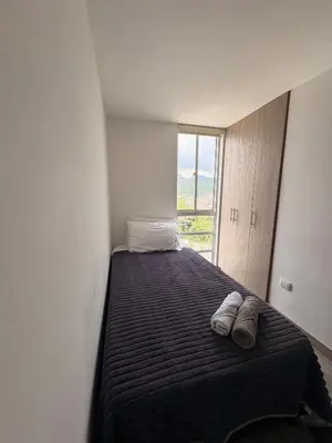 a small bedroom with a bed with a window at Apartamento en Manizales in Manizales