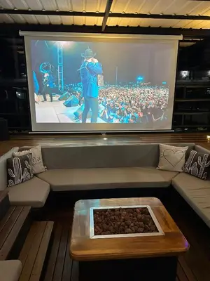 a large screen with a crowd of people watching a concert at Villa Santa Luz in La Pradera