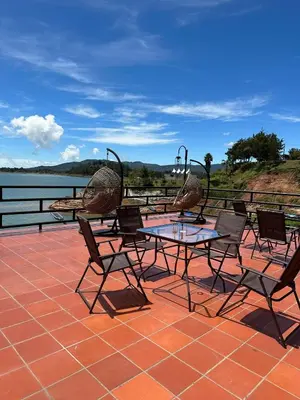 a table and chairs on a patio with a view of the water at Villa Santa Luz in La Pradera
