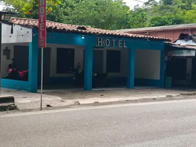 a blue hotel on the side of a street at hotel salome in Puerto Triunfo