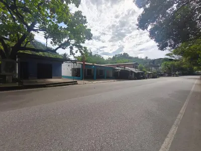 an empty street in a town with trees and buildings at hotel salome in Puerto Triunfo