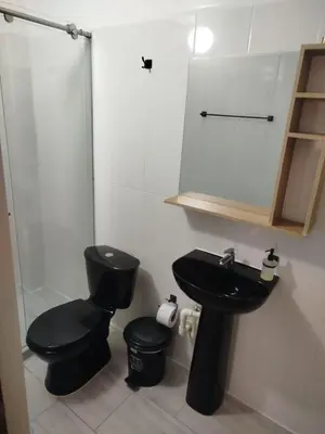 a bathroom with a black toilet and a sink at hotel salome in Puerto Triunfo