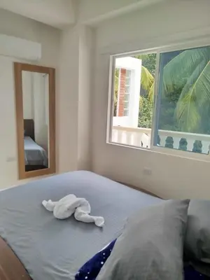 a towel animal laying on a bed with a window at hotel salome in Puerto Triunfo