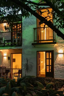 a green building with a window and a balcony at Palma Serena Finca Hotel in Santa Fe de Antioquia