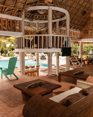 a living room with couches and tables and a pool at Palma Serena Finca Hotel in Santa Fe de Antioquia